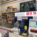 Interior of a Korean convenience store with a self checkout machine and snack shelves