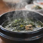 steaming Korean seaweed soup served hot in a black bowl