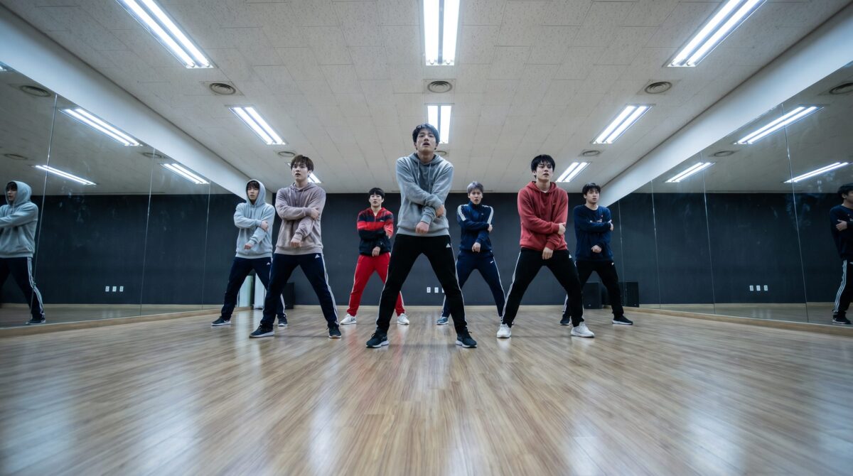 K-pop trainees practicing dance choreography in a large mirrored practice room in Seoul South Korea