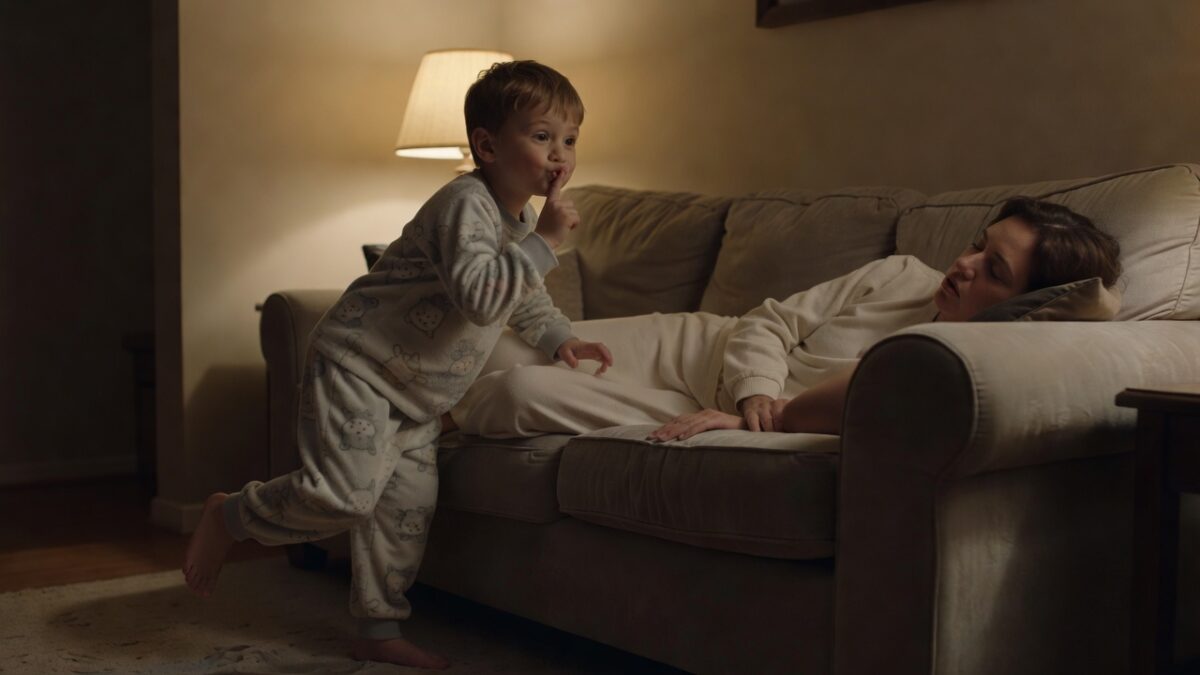 Child sneaking past a sleeping family member in a dim living room at night